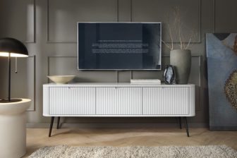 Biała szafka RTV frezowana na wysokich nogach