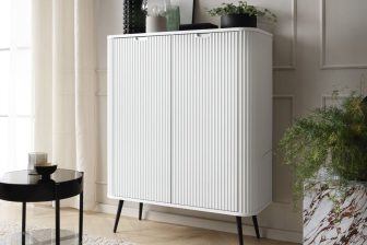 Biała wysoka komoda frzowana na wysokich nogach