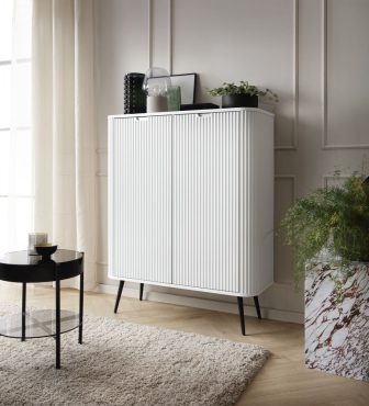 Biała wysoka komoda frzowana na wysokich nogach