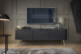 Czarna szafka RTV z frezownami frontami i złotymi nogami